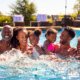 Portrait Of Smiling Multi-Generation Family On Summer Holiday Relaxing In Swimming Pool